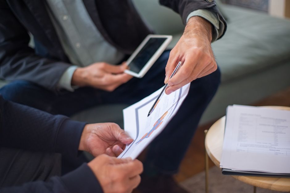 Advogado e cliente revisando cláusulas contratuais em um ambiente de escritório colaborativo